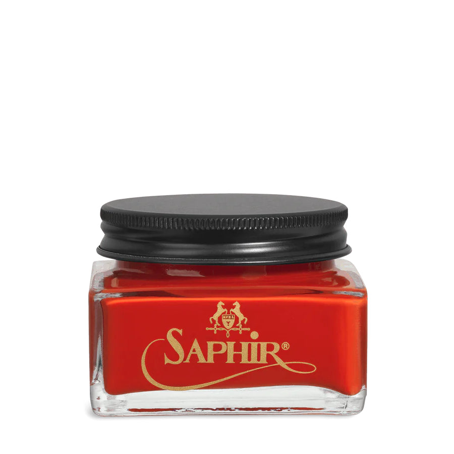 A glass jar with a black lid labeled 'SAPHIR' containing cream shoe polish.