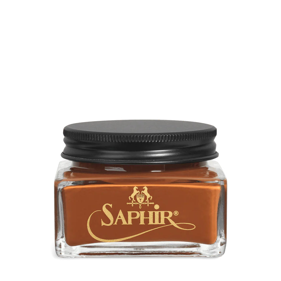 A glass jar with a black lid labeled 'SAPHIR' containing cream shoe polish.