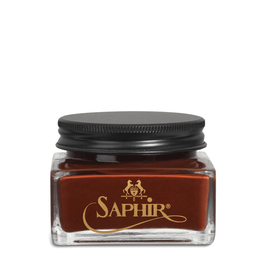 A glass jar with a black lid labeled 'SAPHIR' containing cream shoe polish.