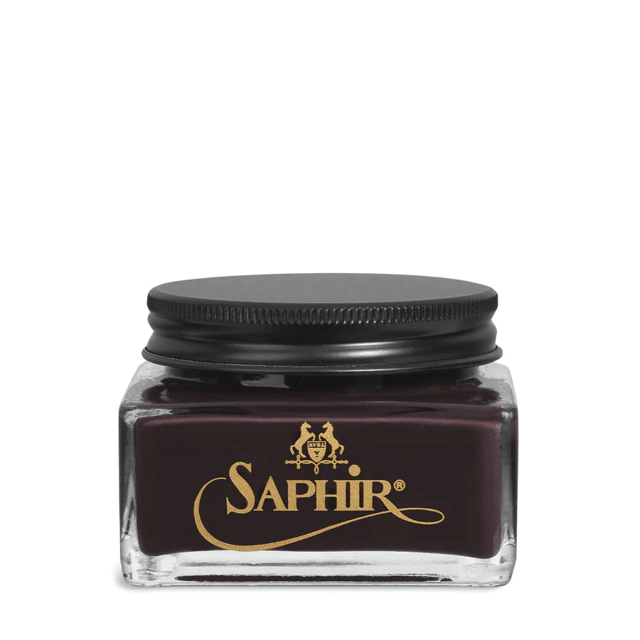 A glass jar with a black lid labeled 'SAPHIR' containing cream shoe polish.