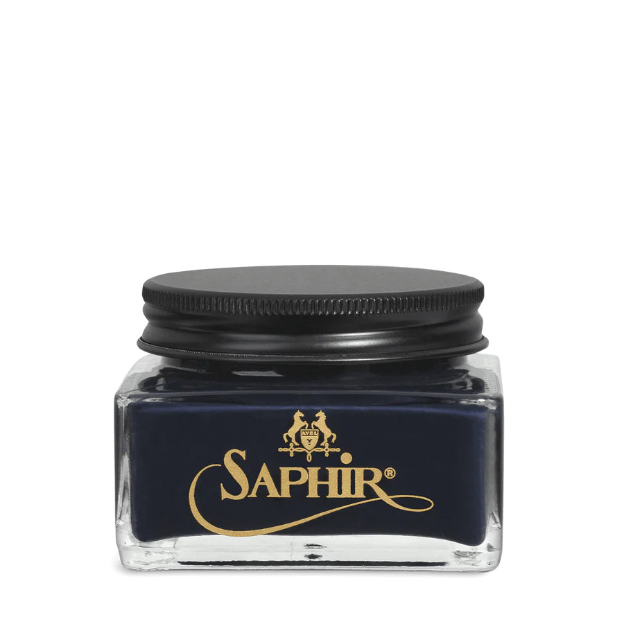 A glass jar with a black lid labeled 'SAPHIR' containing cream shoe polish.