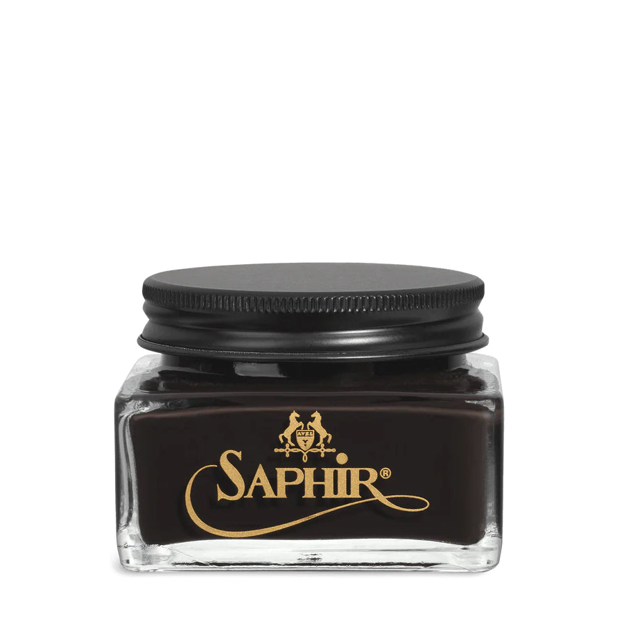 A glass jar with a black lid labeled 'SAPHIR' containing cream shoe polish.