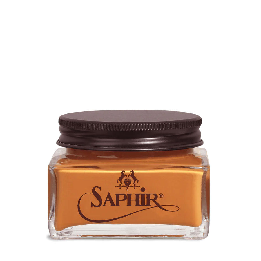 A glass jar with a black lid labeled 'SAPHIR' containing cream shoe polish.