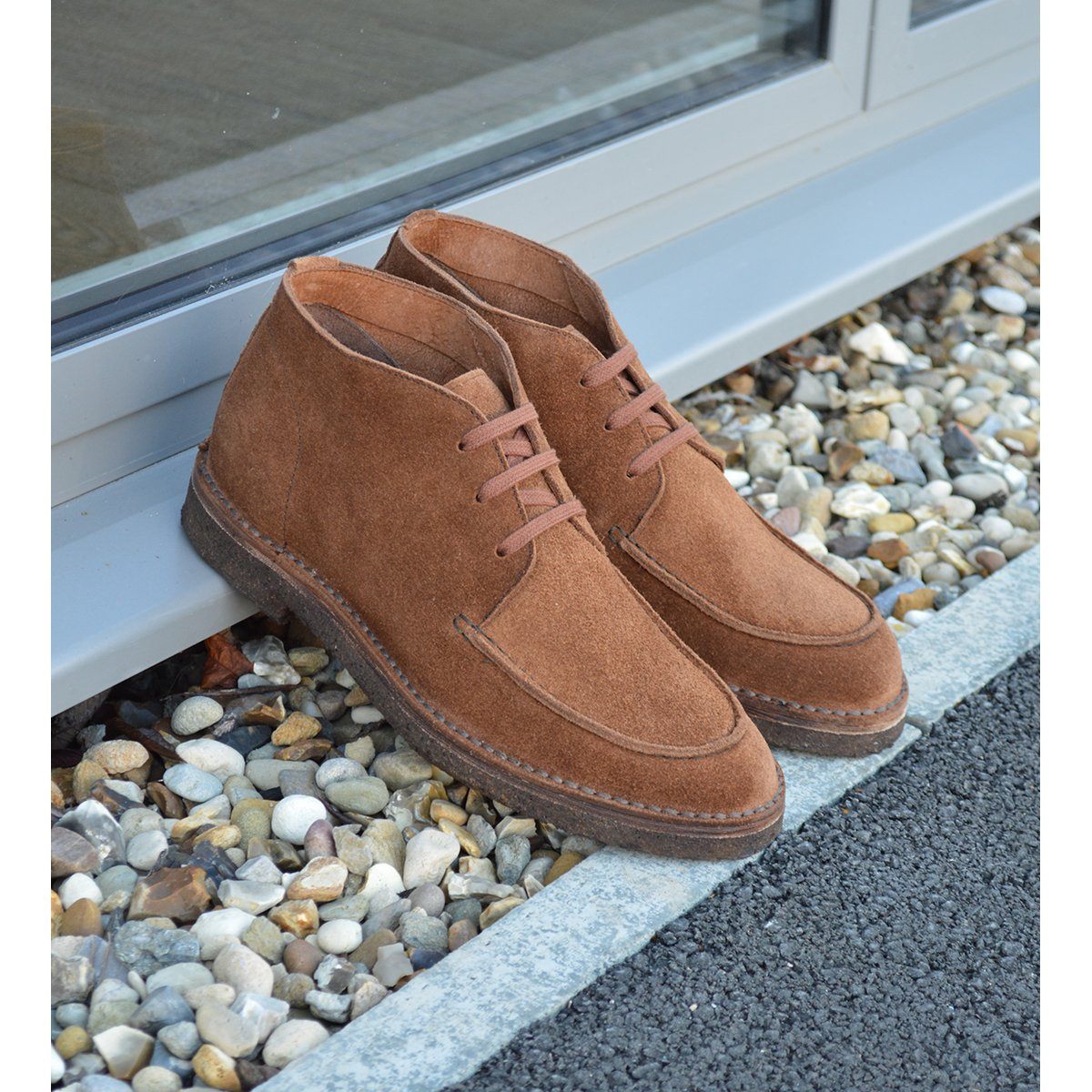 A brown Berwick 1707 5432 Apron Boot with lace-up closure, handcrafted from reverse kudu suede, featuring moccasin stitching and a crepe rubber sole.