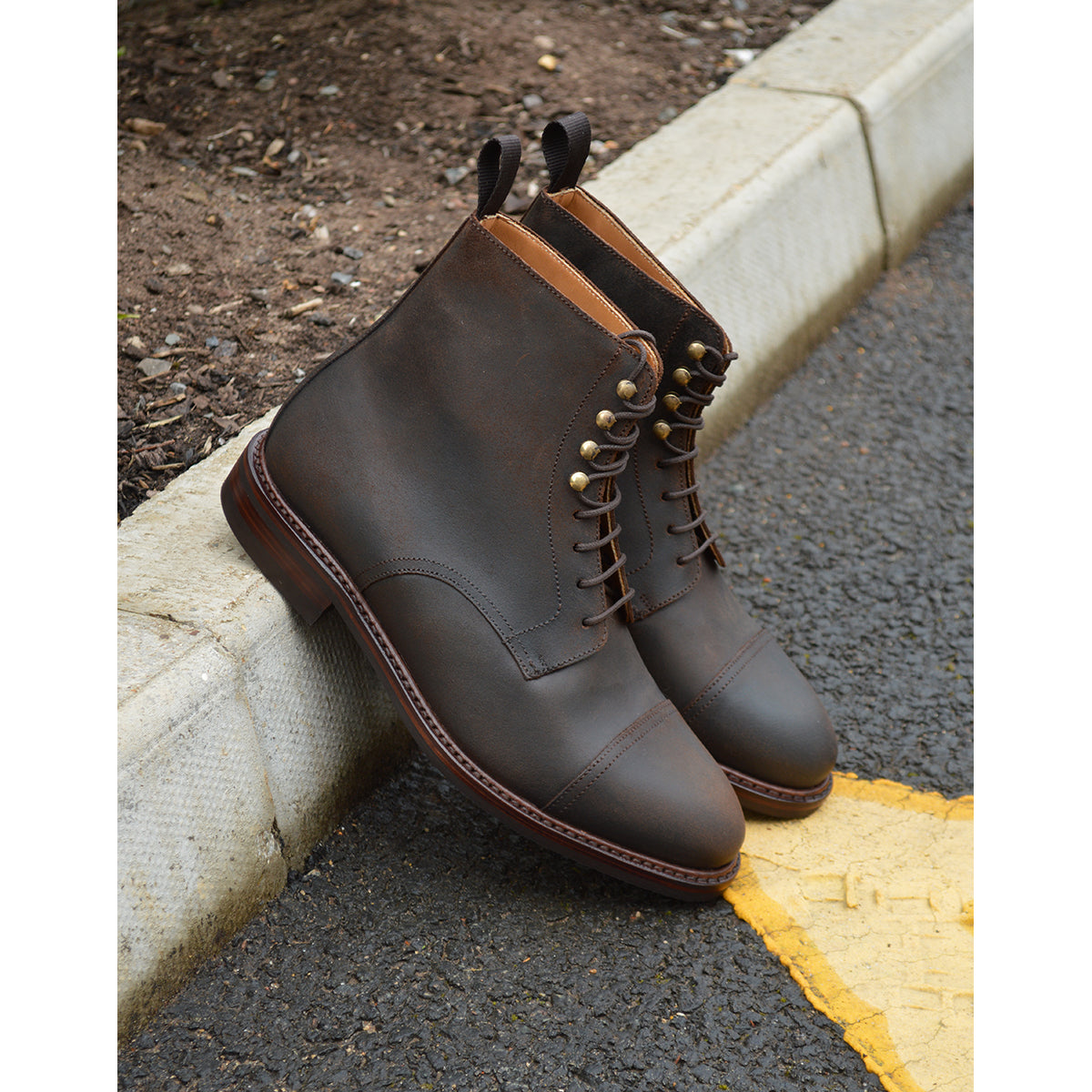 A Berwick 1707 dark brown, waxed roughout suede classic country toe cap derby boot with Dainite rubber sole and lace-up closure.