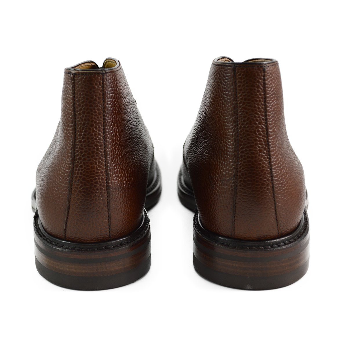 A dark brown grain leather chukka boot with a round toe and goodyear welted dainite rubber sole.