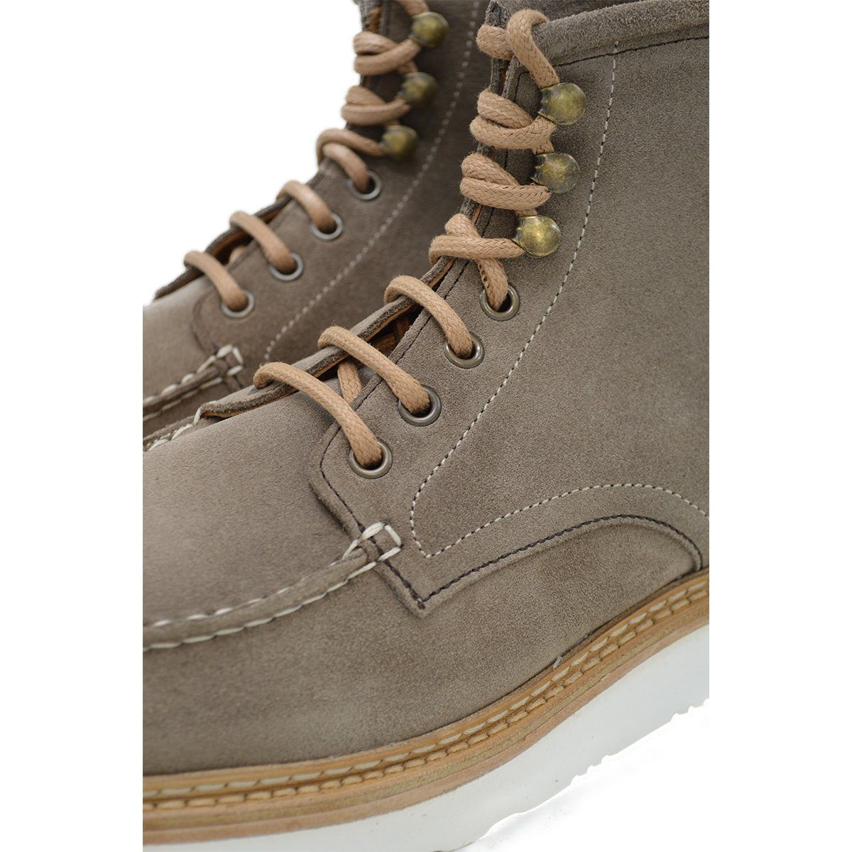 A grey and tan suede apron boot with lace-up closure, featuring a white sole and a natural welt.