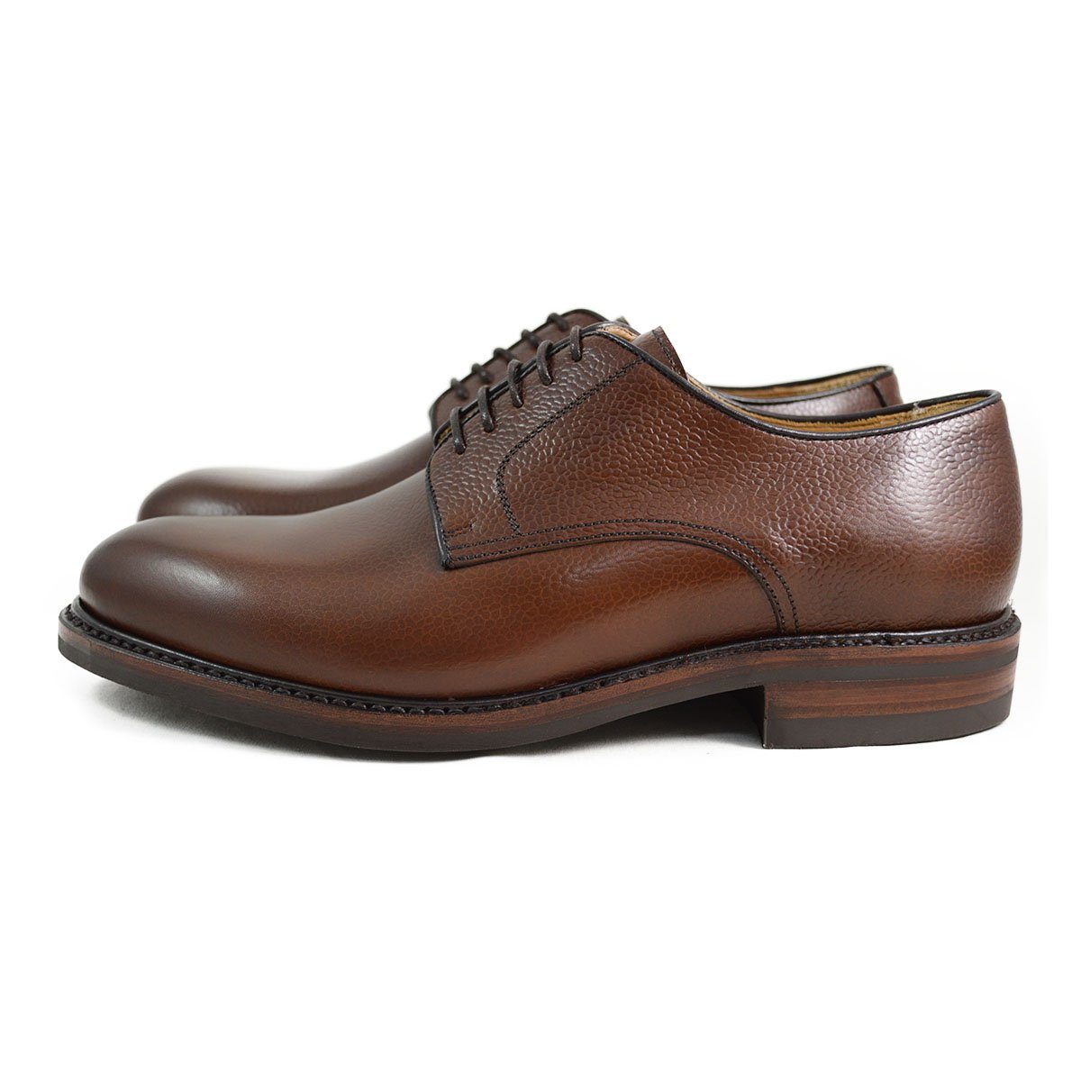 A dark brown, grainy-textured leather derby shoe with a round toe and classic lace-up closure & Dainite soles