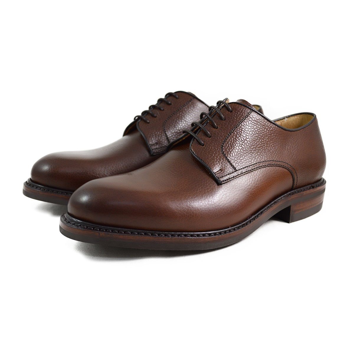 A dark brown, grainy-textured leather derby shoe with a round toe and classic lace-up closure & Dainite soles