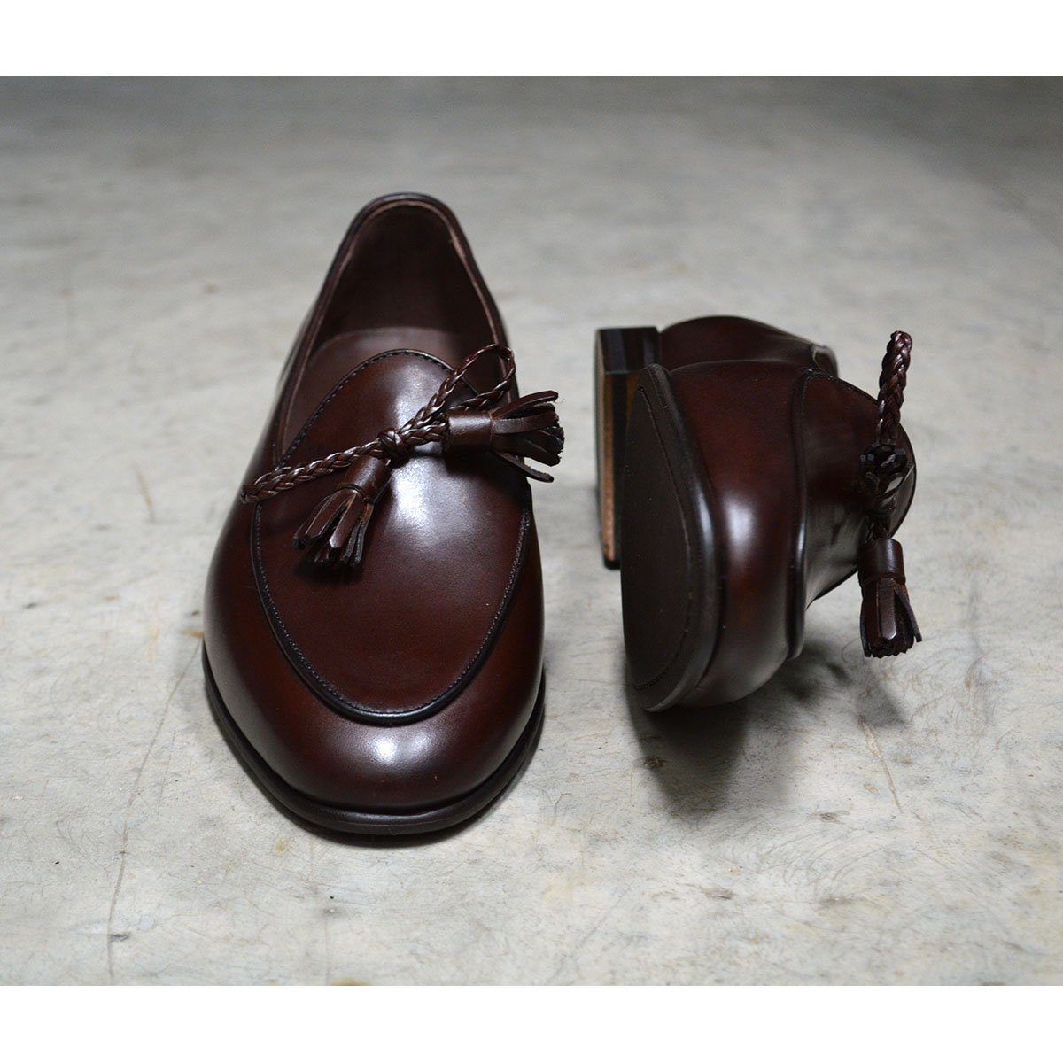 A Berwick 1 707 dark brown leather Belgian loafer with a braided leather bow tie and tassel adornment.