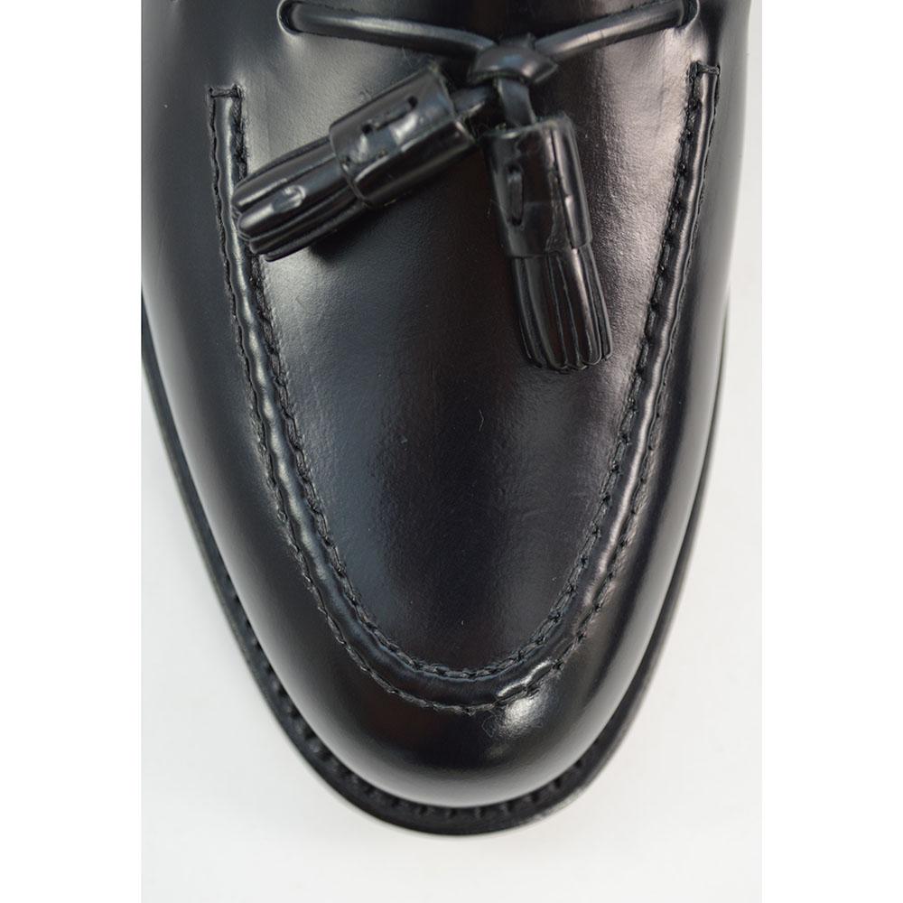 A black tasselled slip-on shoe with a high shine finish and a classic round toe.
