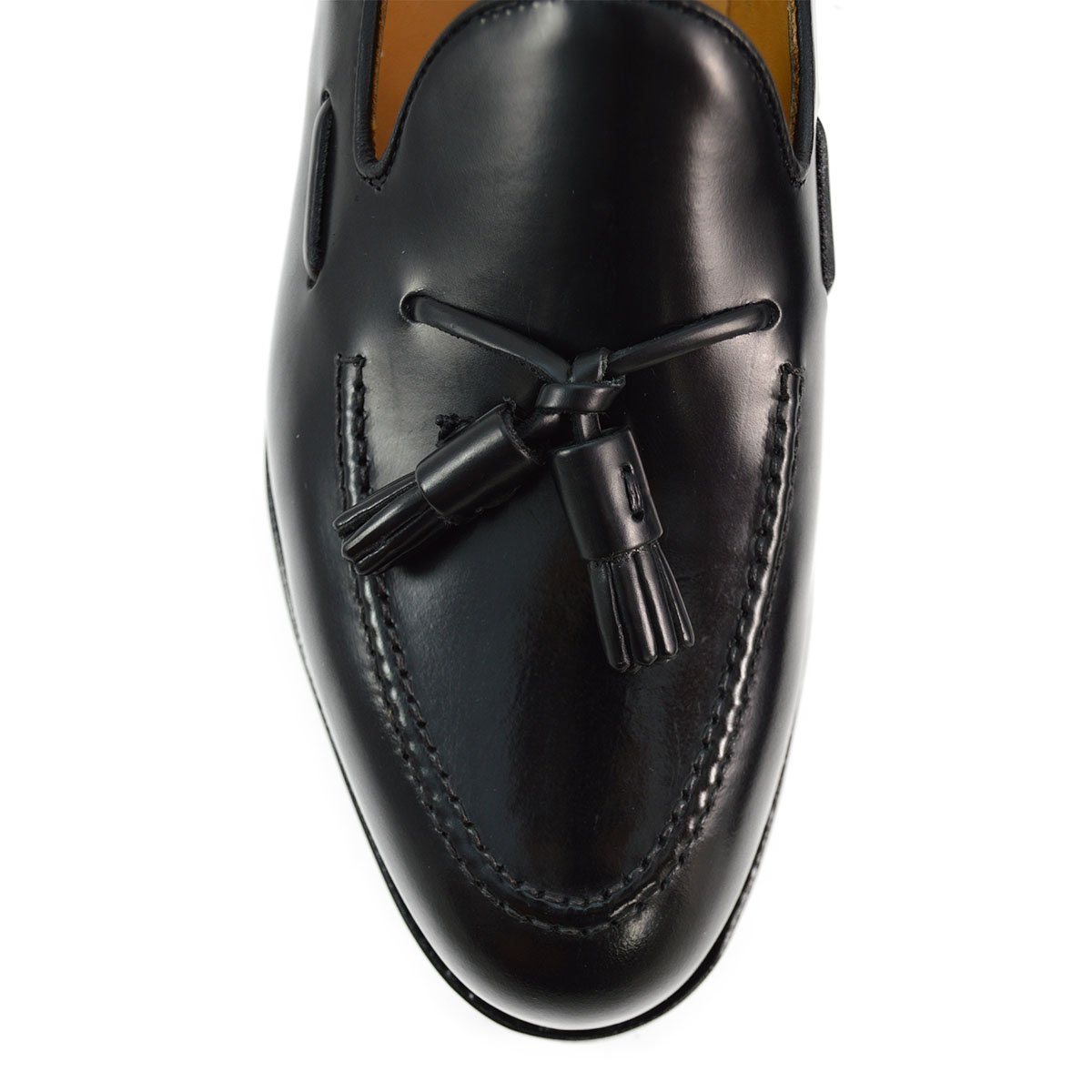 A black tasselled slip-on shoe with a polished, smooth upper and a classic round toe. The shoe is set against a white background.