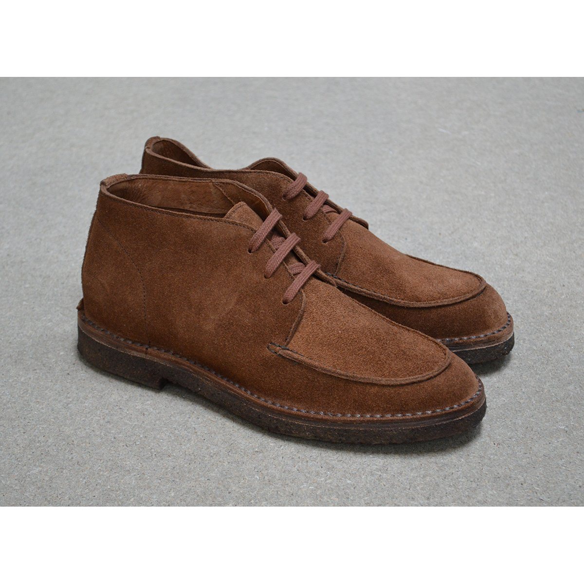 A brown Berwick 1707 5432 Apron Boot with lace-up closure, handcrafted from reverse kudu suede, featuring moccasin stitching and a crepe rubber sole.