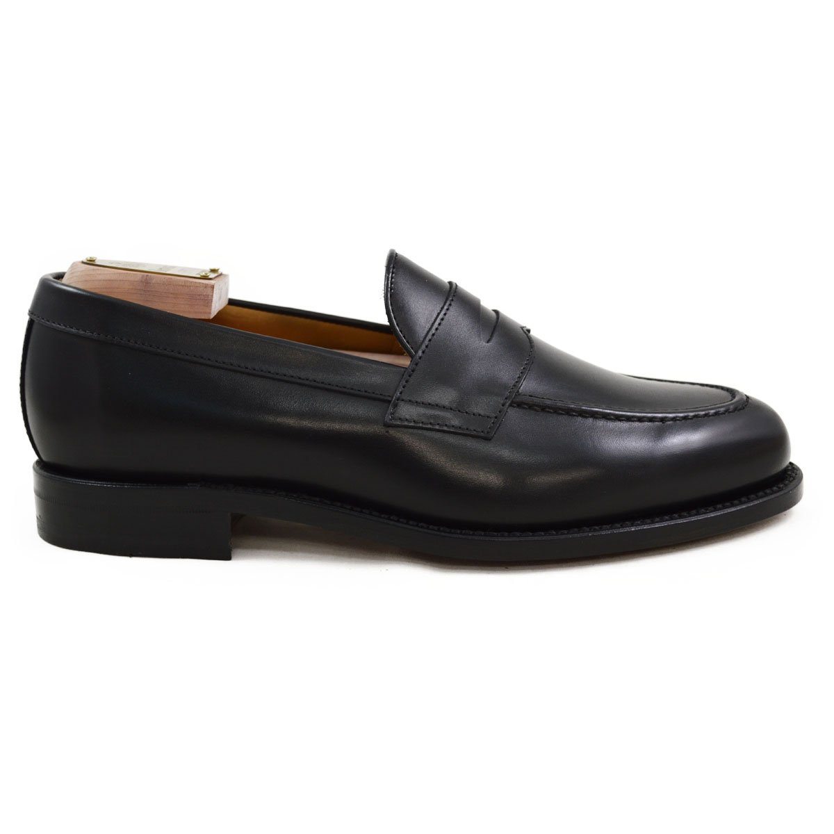 A classic black leather penny loafer shoe for men, with a closed vamp and a low heel.