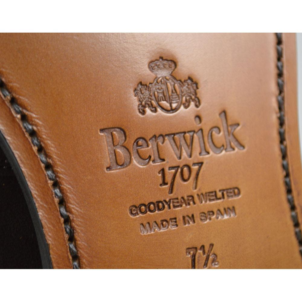A Berwick 1707 dark brown suede penny loafer with a Goodyear welted leather sole, displayed on a white background.