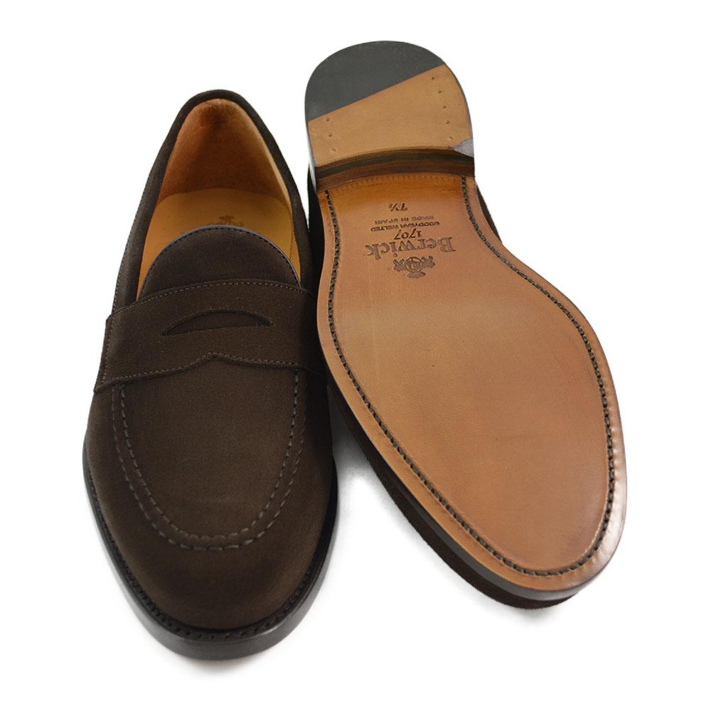 A dark brown suede penny loafer with a Goodyear welted leather sole, displayed on a white background.