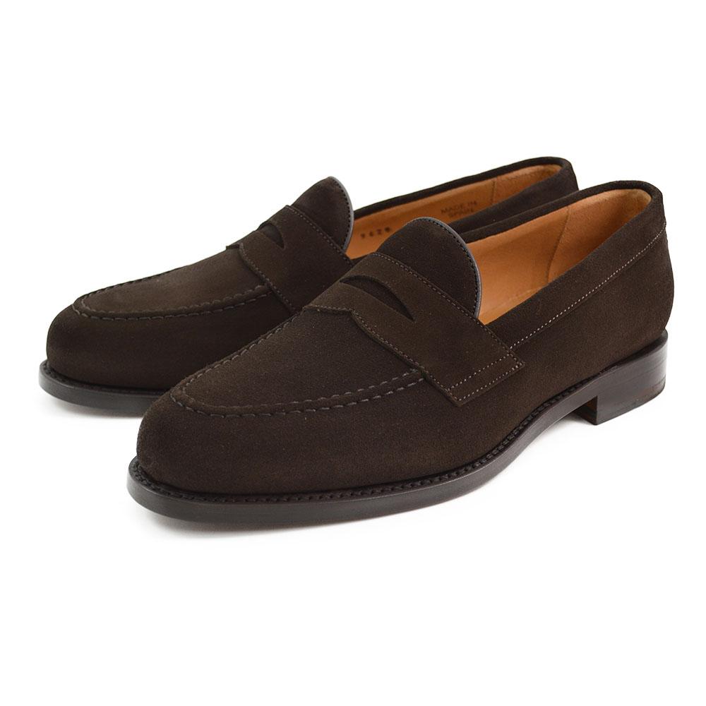 A dark brown suede penny loafer with a classic round toe shape and a low heel.
