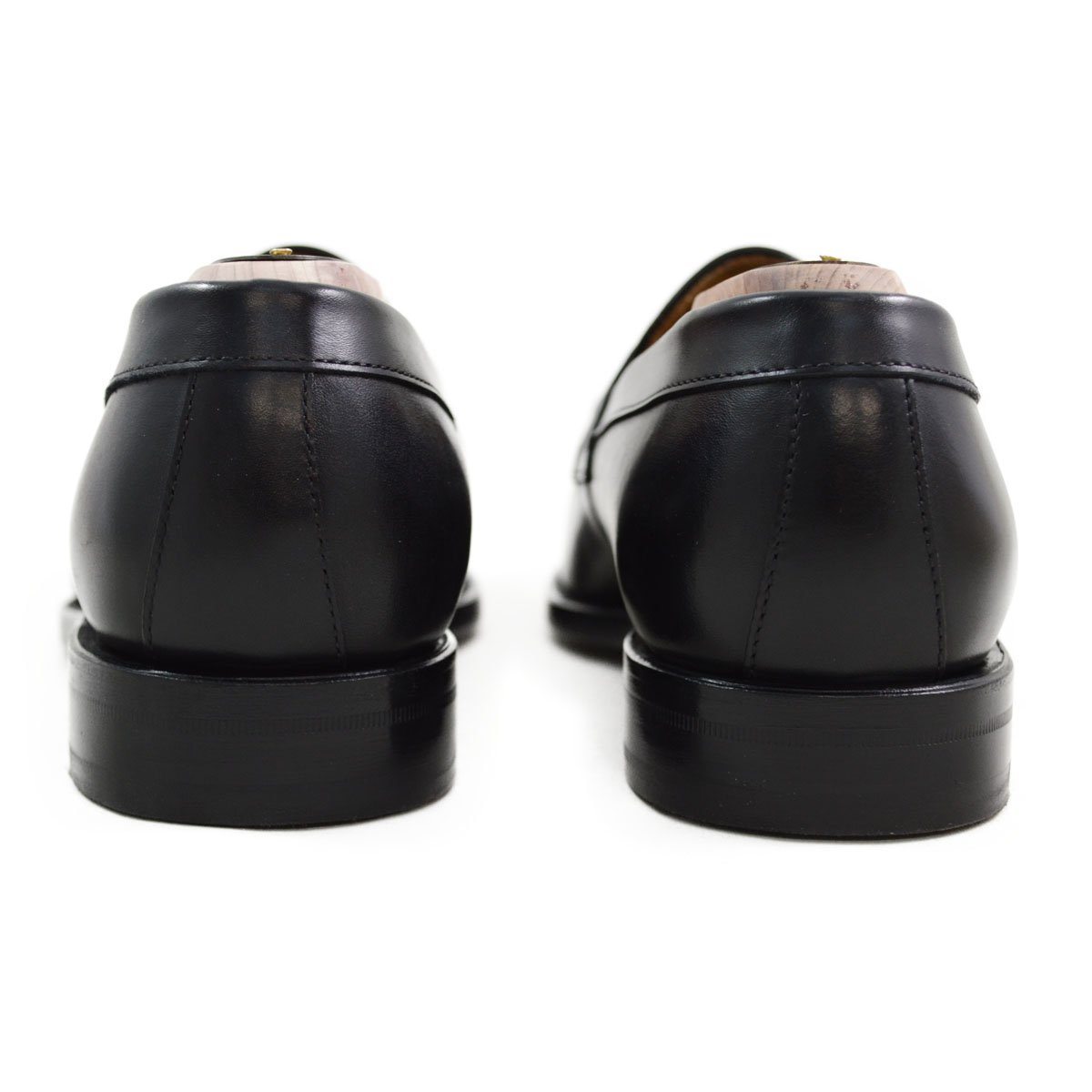 A classic black leather penny loafer shoe for men, with a closed vamp and a low heel.