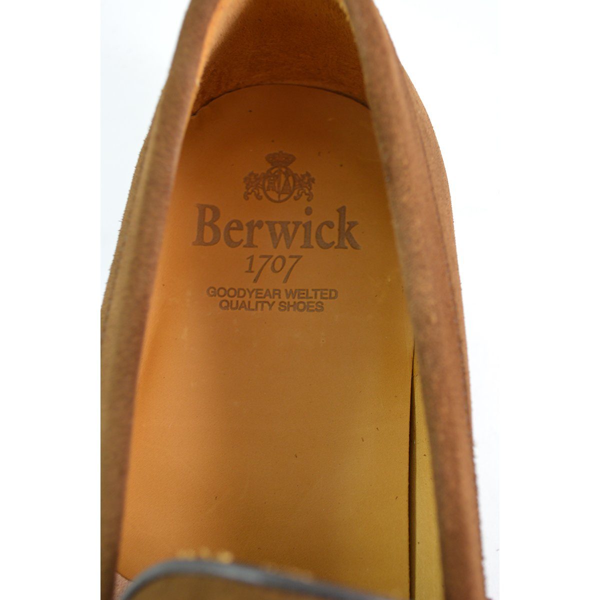 A brown suede penny loafer with a Dainite rubber sole, showing a classic round toe shape and a signature penny slot detail & Dainite Soles