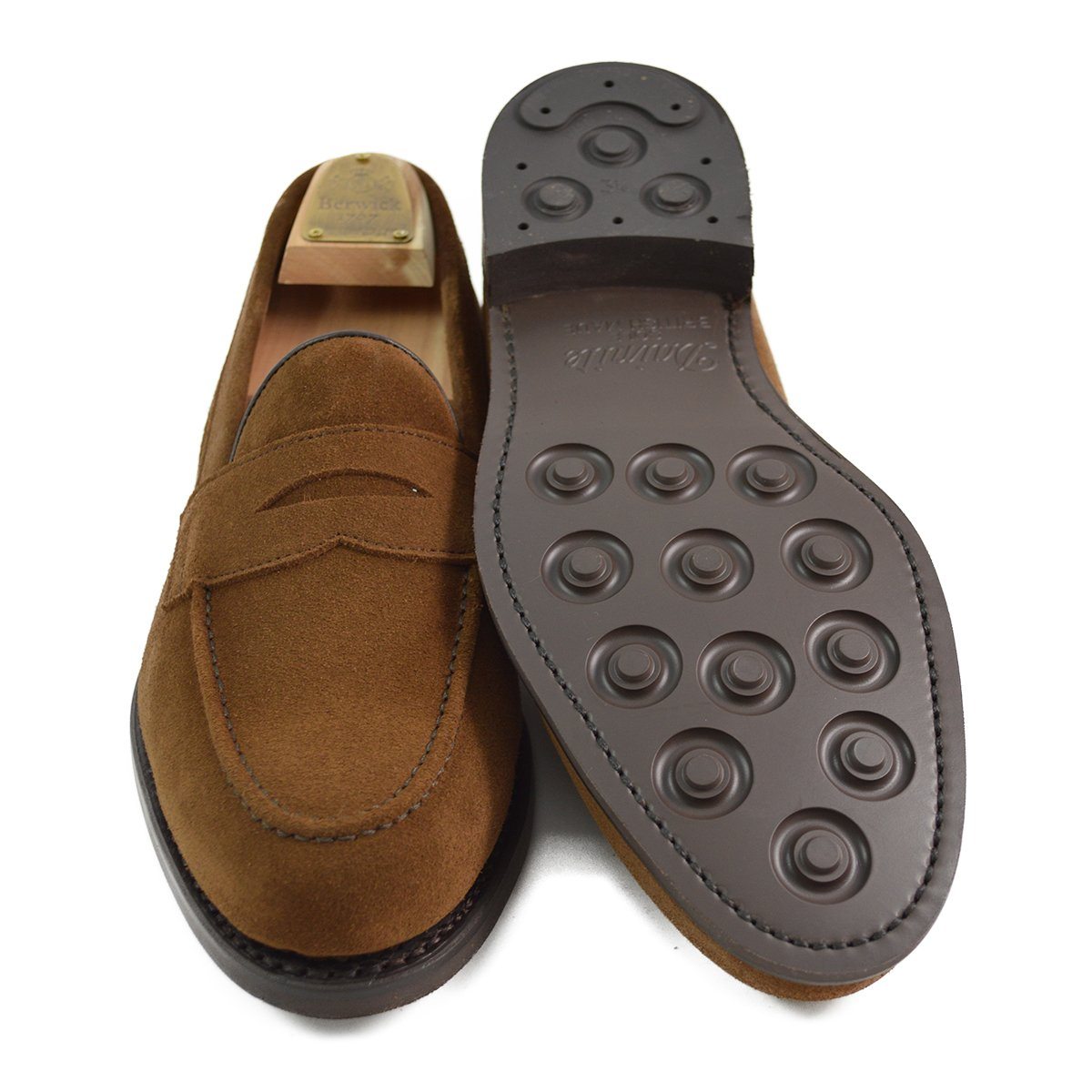 A brown suede penny loafer with a Dainite rubber sole, showing a classic round toe shape and a signature penny slot detail & Dainite Soles