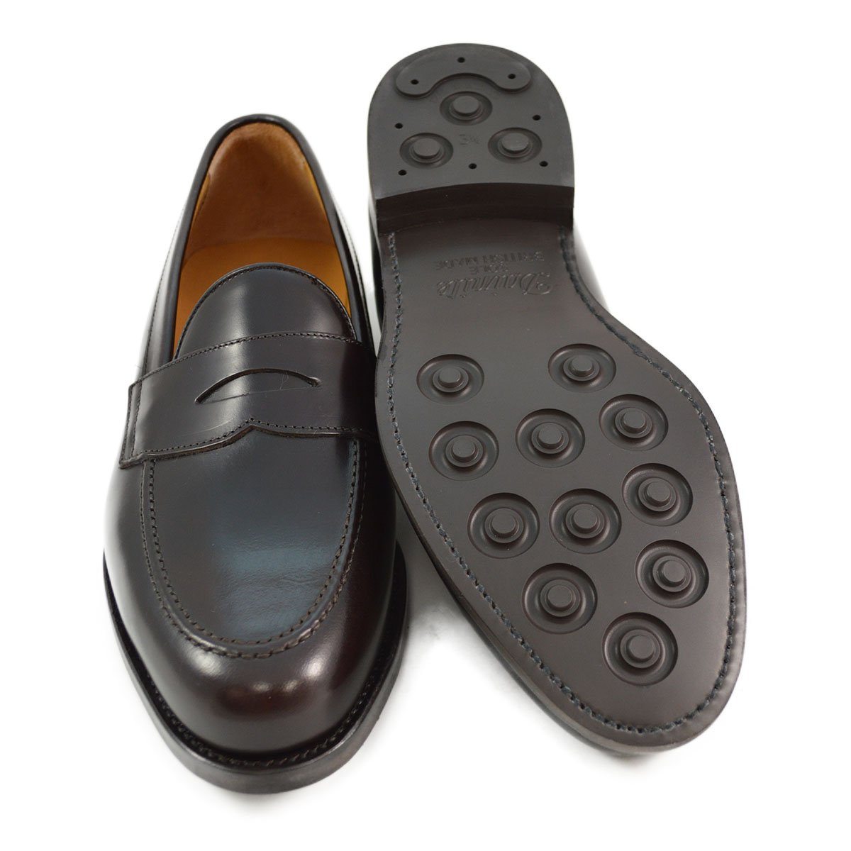 A dark brown Berwick 1707 Penny Loafer with a high-shine finish and a Dainite rubber sole.
