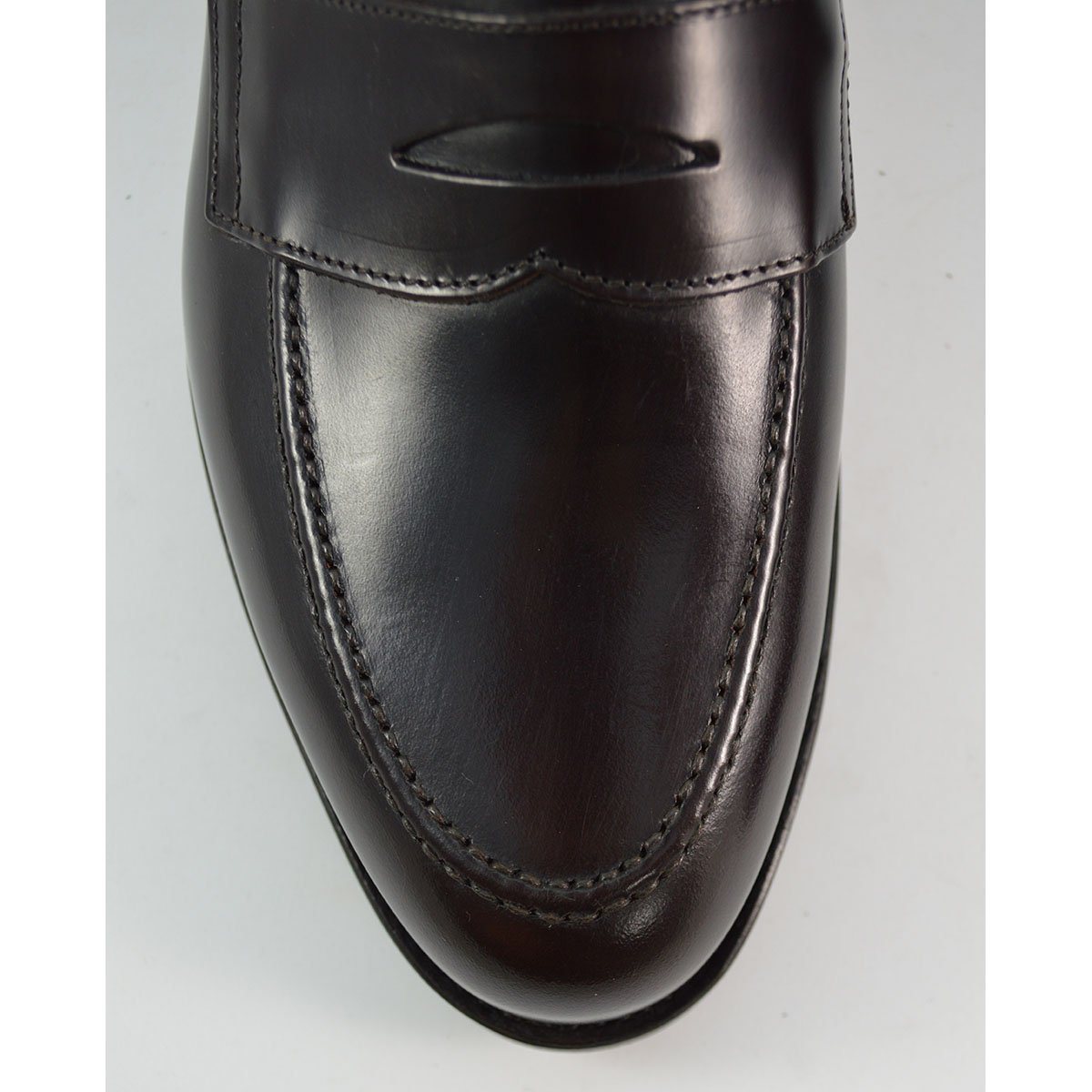 A dark brown Berwick 1707 Penny Loafer with a high-shine finish and a Dainite rubber sole.