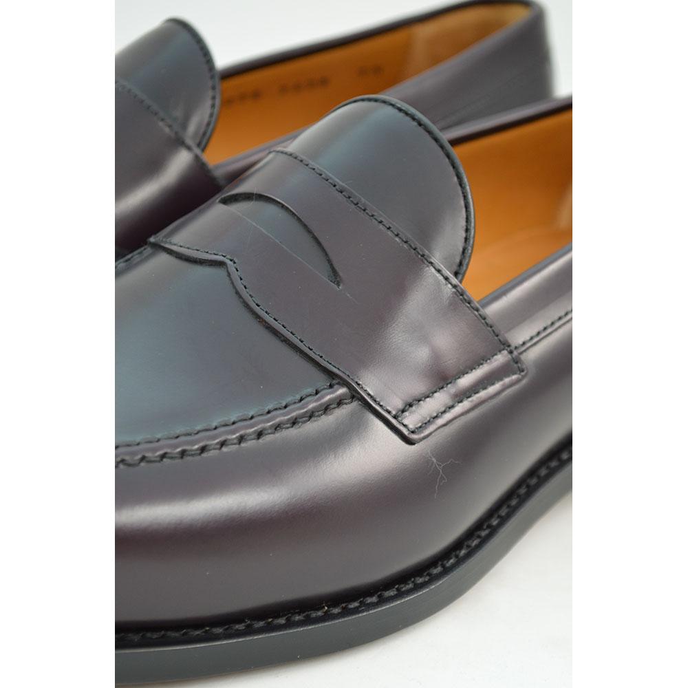 A burgundy high-shine leather penny loafer by Berwick 1707, displaying the classic round toe shape and the brand's distinctive penny slot detail.