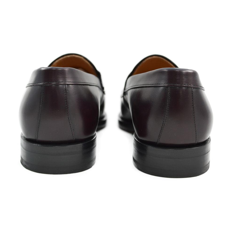 A burgundy high-shine leather penny loafer by Berwick 1707, displaying the classic round toe shape and the brand's distinctive penny slot detail.