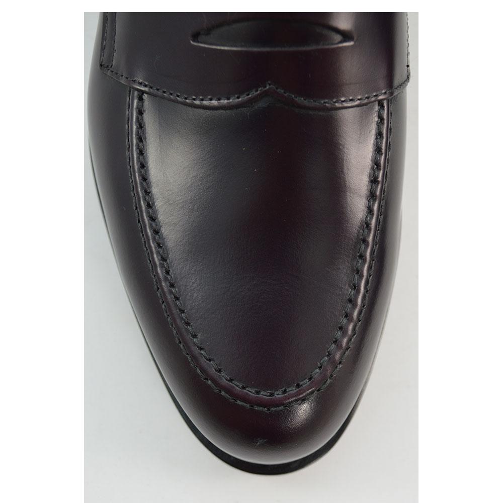 A burgundy high-shine leather penny loafer by Berwick 1707, displaying the classic round toe shape and the brand's distinctive penny slot detail.