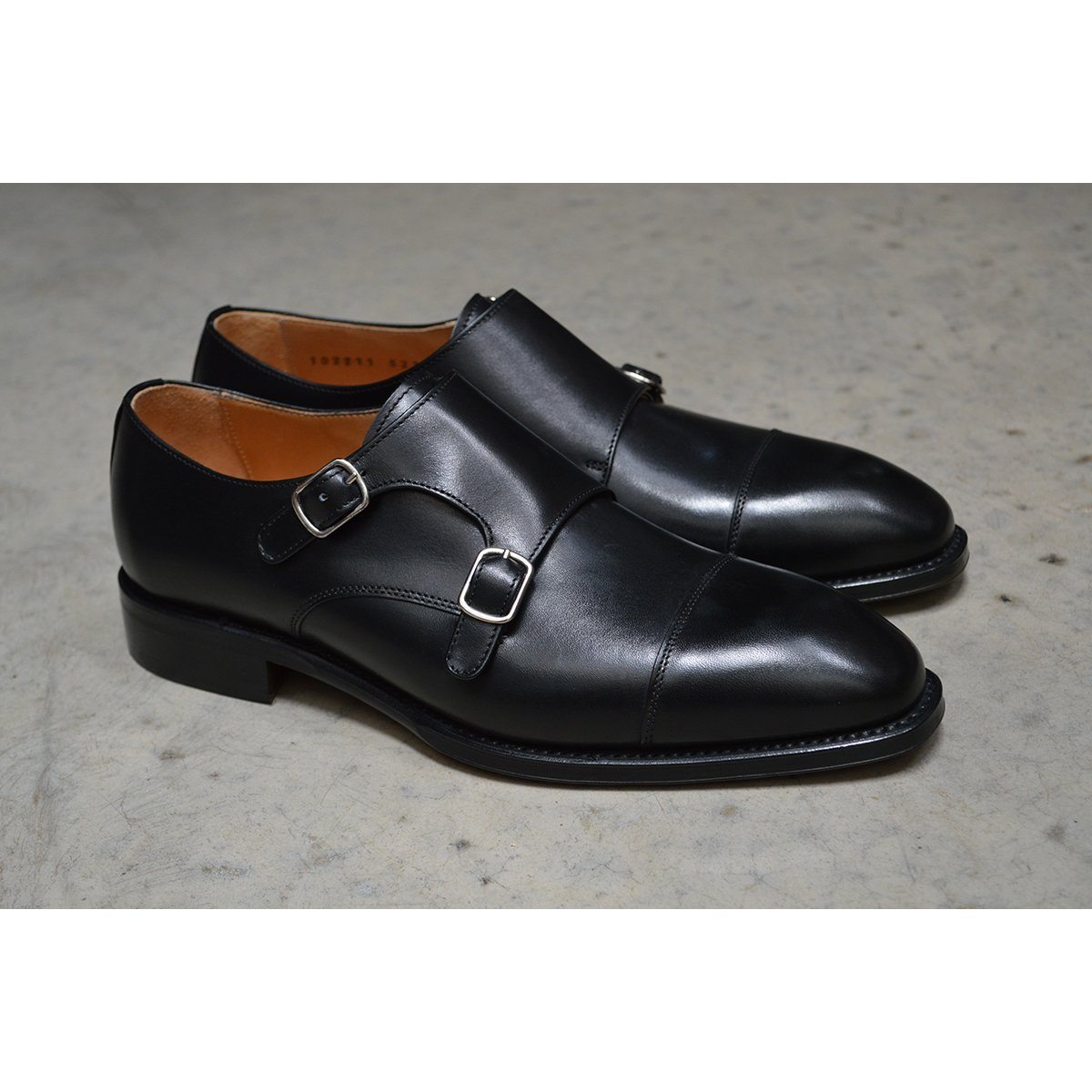 A Berwick 1707 lack double monk shoe with two buckle straps, made from calf leather and featuring a Goodyear welted leather sole.