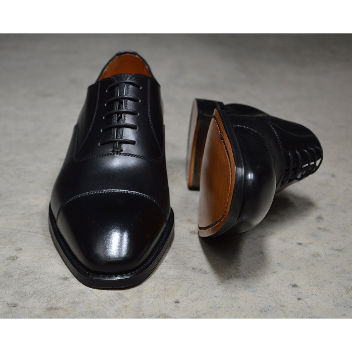 A black, boxcalf leather Oxford shoe with a chisel toe and lace-up closure, crafted in Spain.