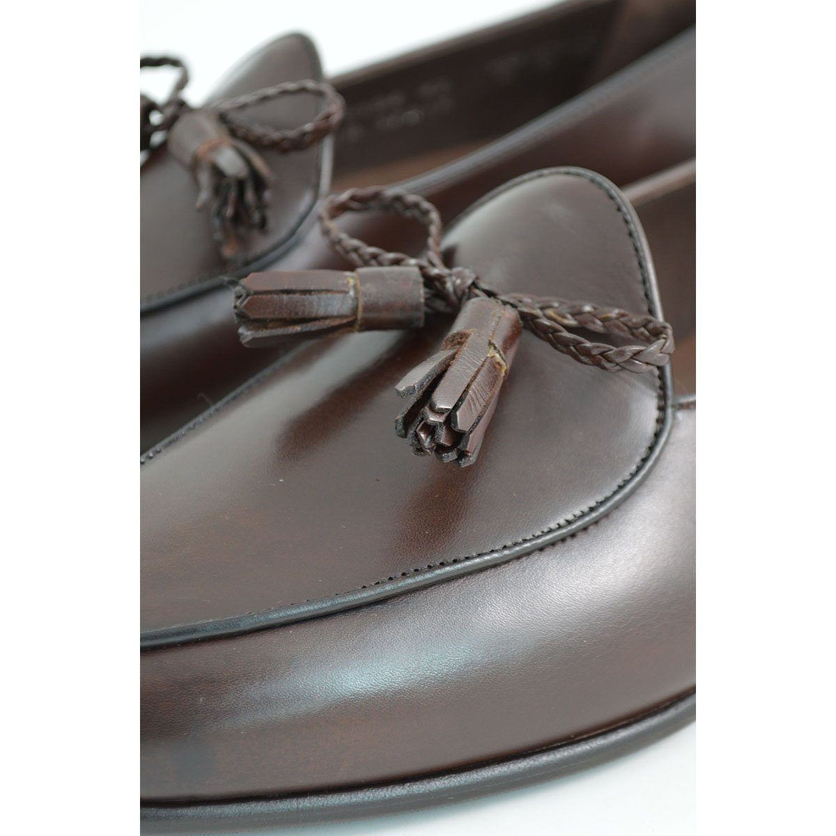 A Berwick 1 707 dark brown leather Belgian loafer with a braided leather bow tie and tassel adornment.