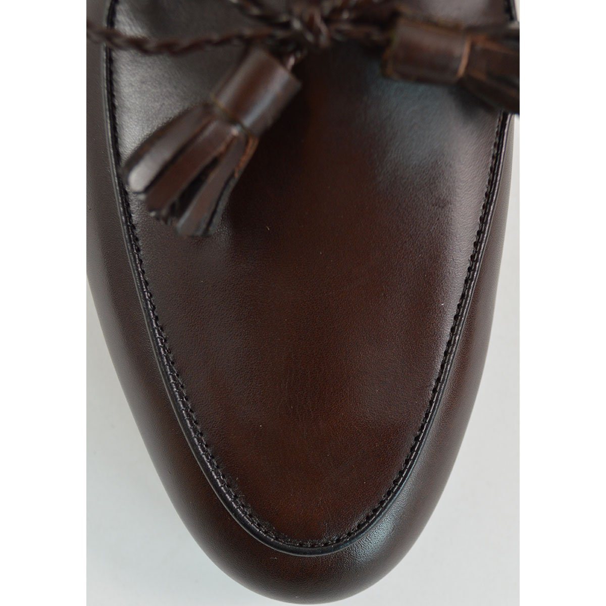 A Berwick 1 707 dark brown leather Belgian loafer with a braided leather bow tie and tassel adornment.