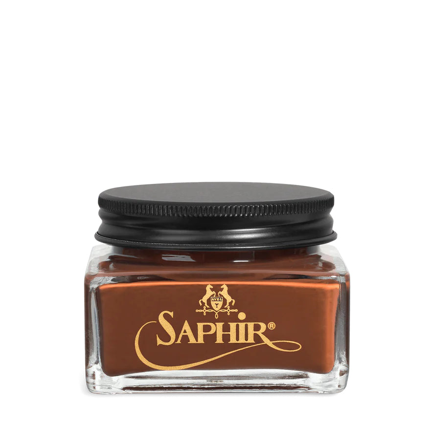 A glass jar with a black lid labeled 'SAPHIR' containing cream shoe polish.