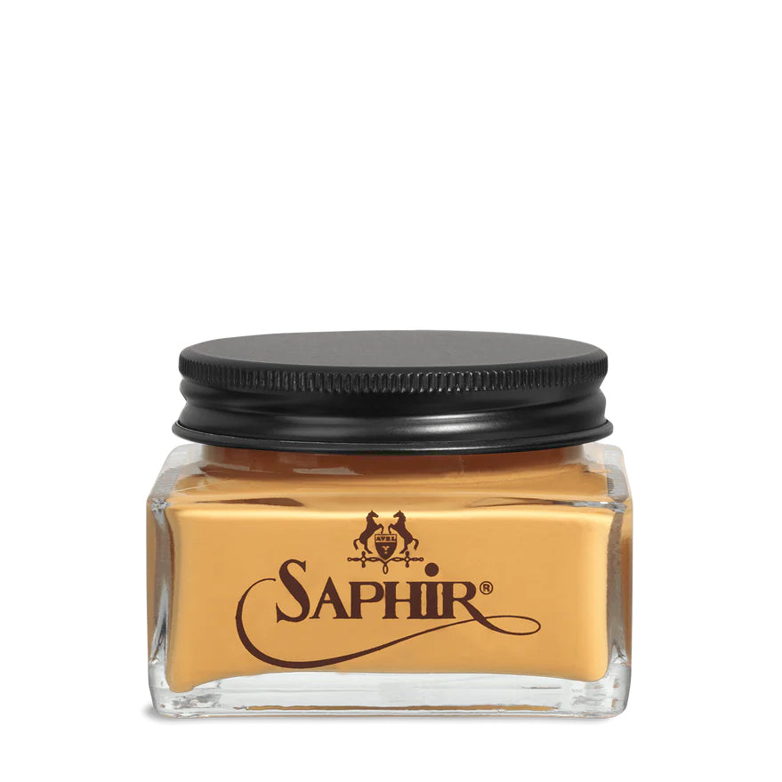 A glass jar with a black lid labeled 'SAPHIR' containing cream shoe polish.