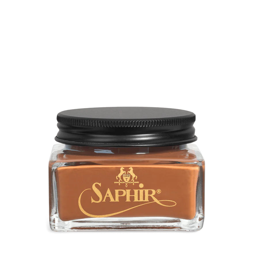 A glass jar with a black lid labeled 'SAPHIR' containing cream shoe polish.