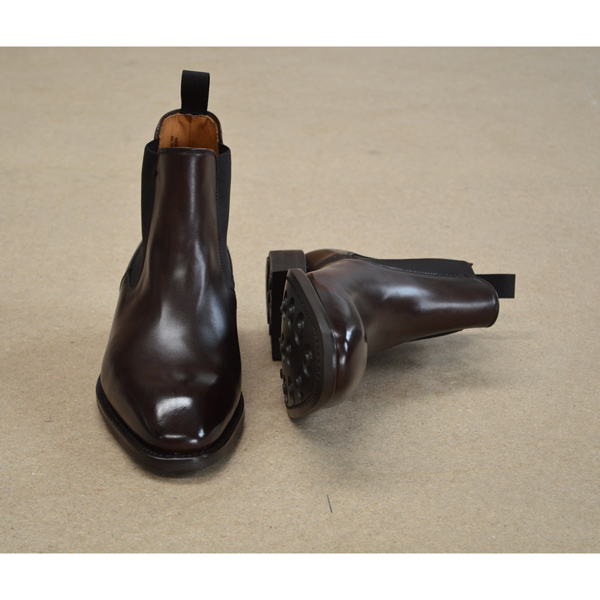 A dark brown leather Chelsea boot with a side pull tab and a low heel & Dainite soles