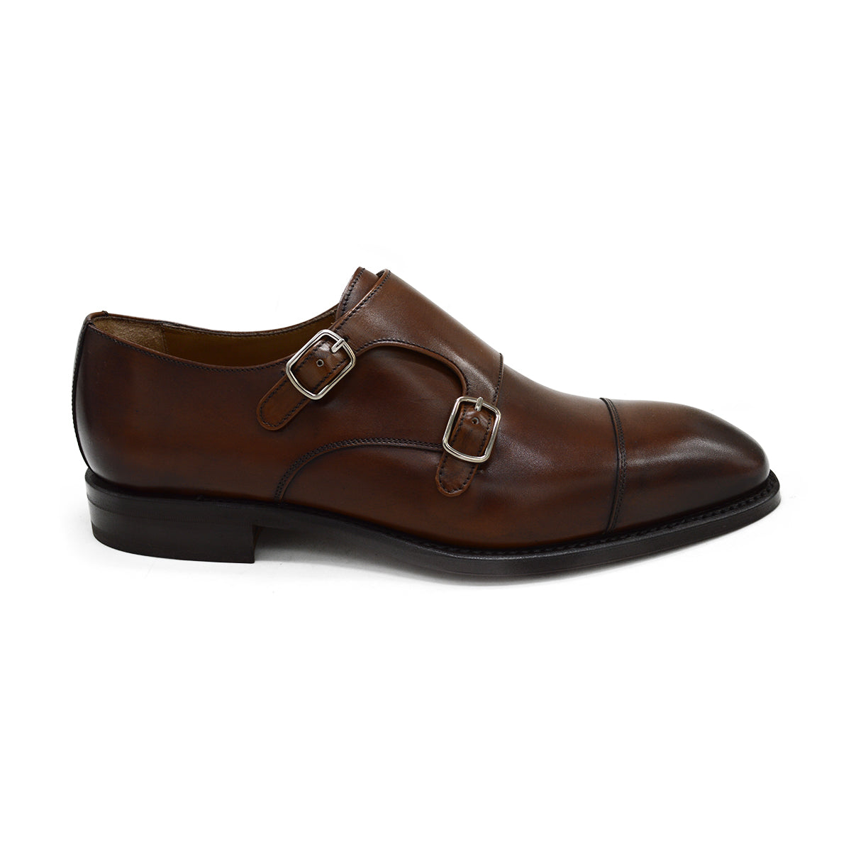 A brown calf leather double monk shoe with two buckle straps, on a white background.