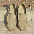 Pair of tan loafers on a stone surface