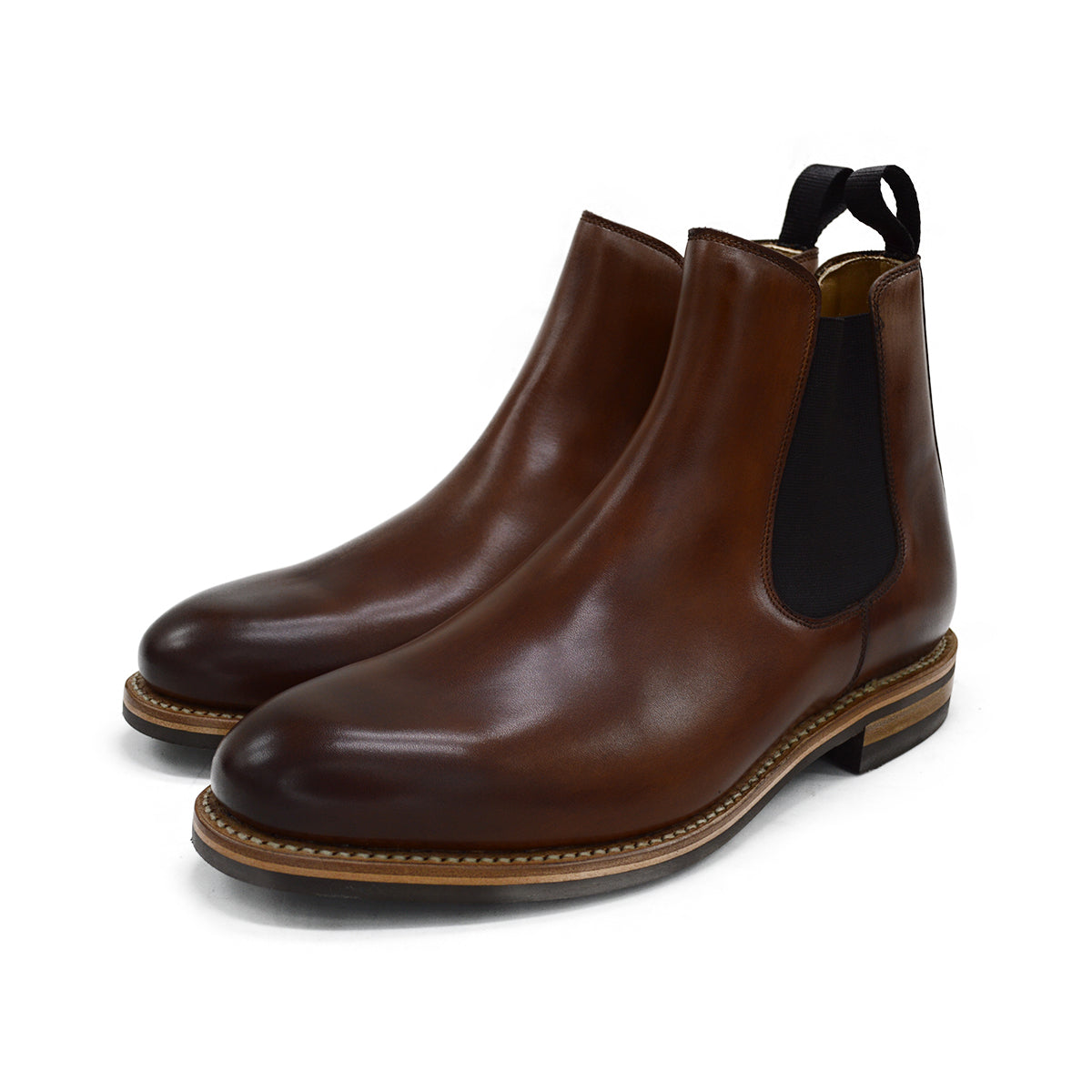 A brown Berwick 1707 Chelsea Boot with a pull tab on the side, showcasing a traditional round-toe shape and a natural welt with a Dainite rubber sole.
