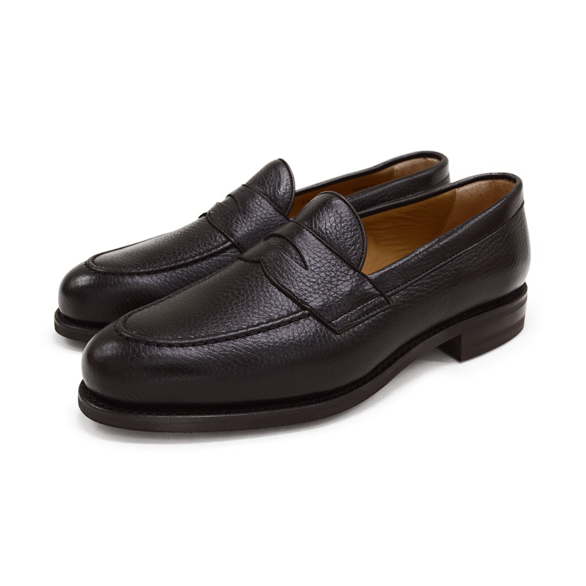 A dark brown deerskin penny loafer with a velvety soft texture and a classic round toe shape on a white background with Dainite Studded Rubber Sole.