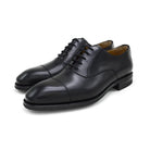 A Berwick 1707 black leather Oxford shoe with a chisel toe and lace-up closure with a Dainite rubber studded sole, on a white background.