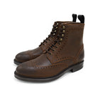 A dark brown lace-up brogue boot with a rubber sole and visible stitching on the upper part.