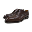 A Berwick 1707 dark brown, chisel toe Oxford shoe with a lace-up closure and a single leather sole.