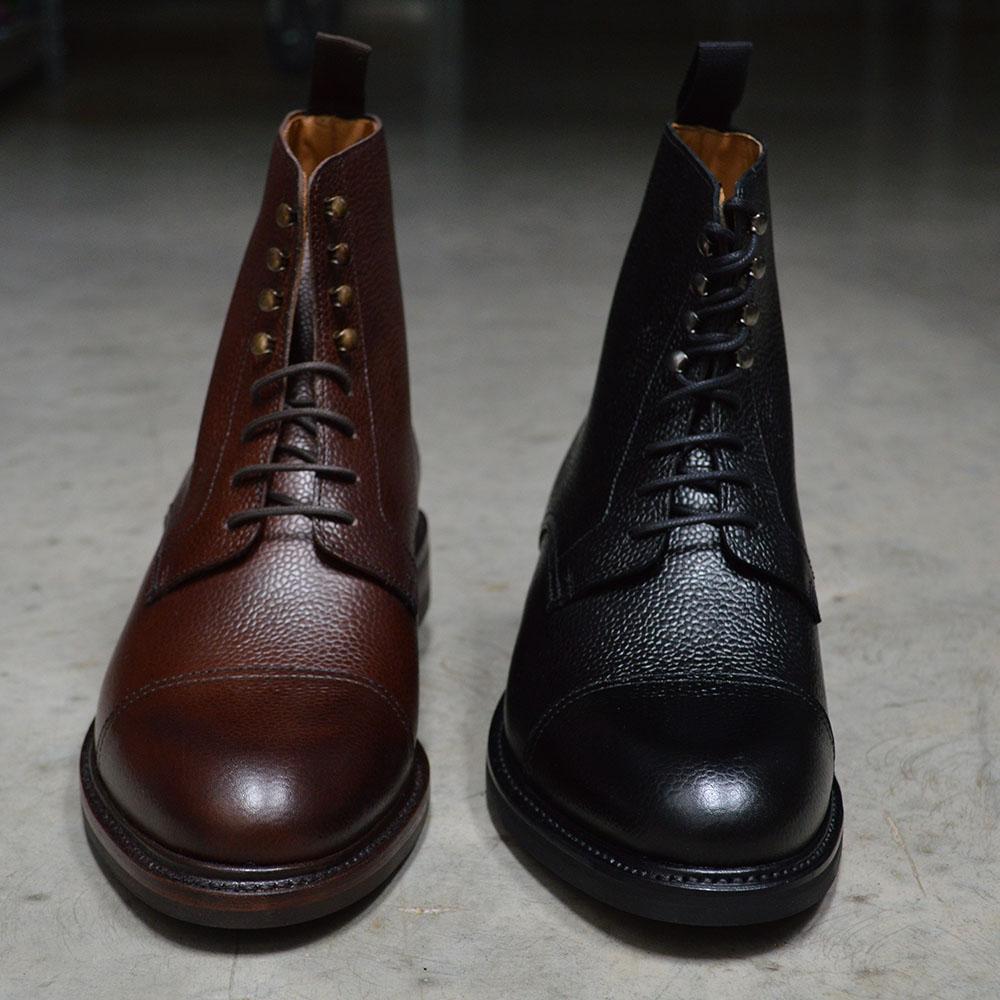 A Berwick 1707 brown & black grain toe cap boot with a full lace-up construction and a round toe shape, set against a polished concrete background.