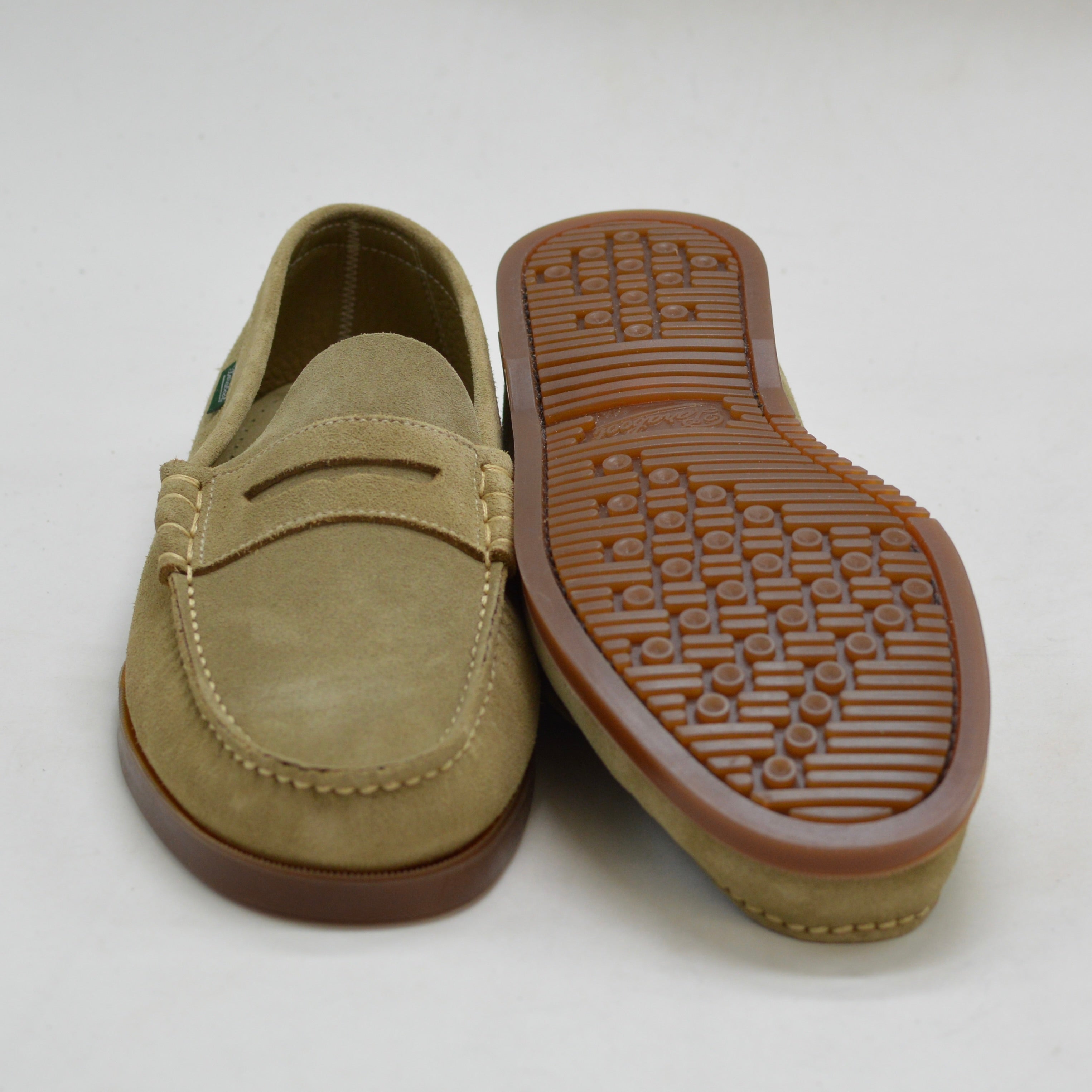 Tan loafer shoe with brown sole on a white background
