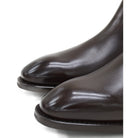 A dark brown leather Chelsea boot with a side pull tab and a low heel & Dainite soles, displayed on a white background.