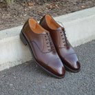 A Berwick 1707 dark brown, chisel toe Oxford shoe with a lace-up closure and a single leather sole.