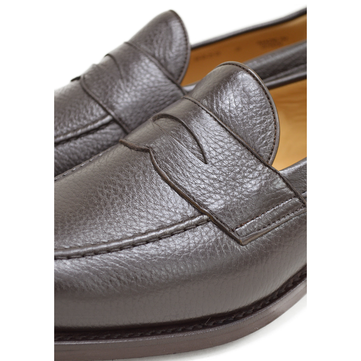 A dark brown deerskin penny loafer with a velvety soft texture and a classic round toe shape on a white background with Dainite Studded Rubber Sole.