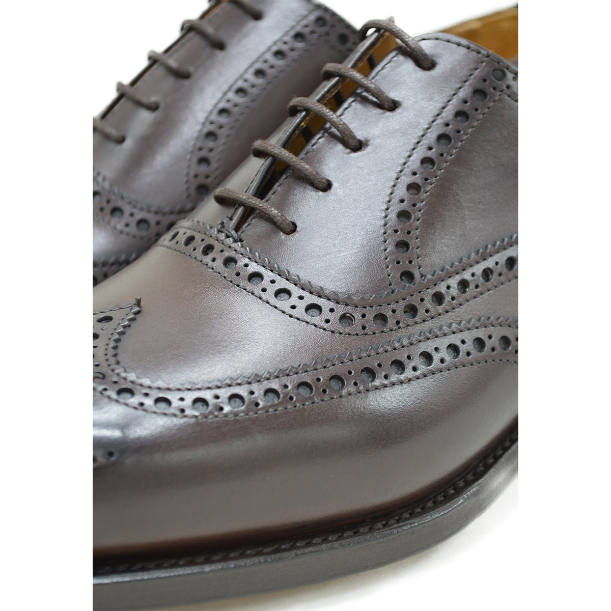 A dark brown Oxford brogue shoe with intricate brogue detailing and a goodyear welted leather sole.